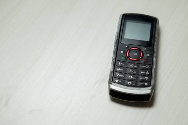 Eski hücresel cihaz merkez ofisteki masanın üstüne yerleştirilmiş, ekranı, klavyeyi ve eski elektronik cihaz teknolojisini gösteriyor. Teknoloji konsepti. iletişim konsepti