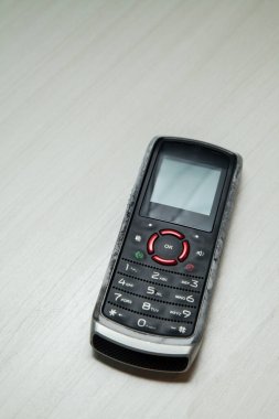 Eski hücresel cihaz merkez ofisteki masanın üstüne yerleştirilmiş, ekranı, klavyeyi ve eski elektronik cihaz teknolojisini gösteriyor. Teknoloji konsepti. iletişim konsepti