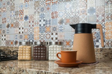 Kahve termoslu kahvaltı masası, bir fincan şeker, kahve ve sos. Arka planda fayanslarla süslenmiş tipik Brezilya mutfağı. Yemek konsepti. Kahvaltı konsepti. 