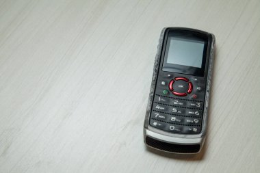 Eski hücresel cihaz merkez ofisteki masanın üstüne yerleştirilmiş, ekranı, klavyeyi ve eski elektronik cihaz teknolojisini gösteriyor. Teknoloji konsepti. iletişim konsepti