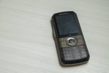 Eski hücresel cihaz merkez ofisteki masanın üstüne yerleştirilmiş, ekranı, klavyeyi ve eski elektronik cihaz teknolojisini gösteriyor. Teknoloji konsepti. iletişim konsepti