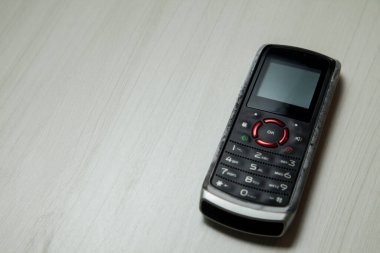 Eski hücresel cihaz merkez ofisteki masanın üstüne yerleştirilmiş, ekranı, klavyeyi ve eski elektronik cihaz teknolojisini gösteriyor. Teknoloji konsepti. iletişim konsepti