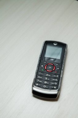 Eski hücresel cihaz merkez ofisteki masanın üstüne yerleştirilmiş, ekranı, klavyeyi ve eski elektronik cihaz teknolojisini gösteriyor. Teknoloji konsepti. iletişim konsepti