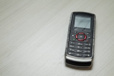 Eski hücresel cihaz merkez ofisteki masanın üstüne yerleştirilmiş, ekranı, klavyeyi ve eski elektronik cihaz teknolojisini gösteriyor. Teknoloji konsepti. iletişim konsepti