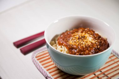 Masaya rendelenmiş peynirli bolonez soslu makarna kasesi. Yemeye hazır ve fotokopi odası var. Yemek konsepti. Makarna konsepti.