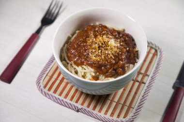 Masaya rendelenmiş peynirli bolonez soslu makarna kasesi. Yemeye hazır ve fotokopi odası var. Yemek konsepti. Makarna konsepti.