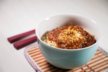 Masaya rendelenmiş peynirli bolonez soslu makarna kasesi. Yemeye hazır ve fotokopi odası var. Yemek konsepti. Makarna konsepti.