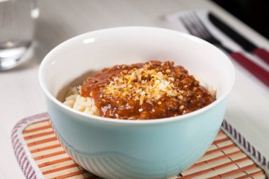 Masaya rendelenmiş peynirli bolonez soslu makarna kasesi. Yemeye hazır ve fotokopi odası var. Yemek konsepti. Makarna konsepti.
