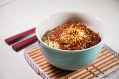 Masaya rendelenmiş peynirli bolonez soslu makarna kasesi. Yemeye hazır ve fotokopi odası var. Yemek konsepti. Makarna konsepti.