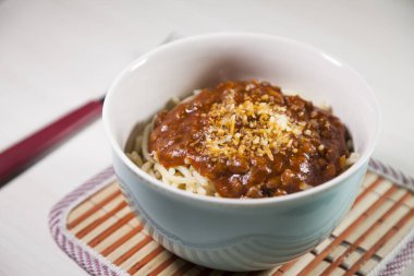 Masaya rendelenmiş peynirli bolonez soslu makarna kasesi. Yemeye hazır ve fotokopi odası var. Yemek konsepti. Makarna konsepti.