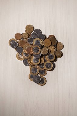 Gerçek para, Brezilya 'dan gelen para. Masanın üzerine para istiflenmiş, üstünde de siyah arka planlı kasvetli ve karanlık iklimli bir bozuk para var. Brezilya ekonomisi, yatırımlar, gelir. Brezilya para birimi 