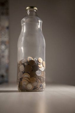 Gerçek para, Brezilya 'dan gelen para. Masanın üzerine para istiflenmiş, üstünde de siyah arka planlı kasvetli ve karanlık iklimli bir bozuk para var. Brezilya ekonomisi, yatırımlar, gelir. Brezilya para birimi 