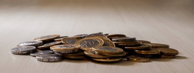 Gerçek para, Brezilya 'dan gelen para. Masanın üzerine para istiflenmiş, üstünde de siyah arka planlı kasvetli ve karanlık iklimli bir bozuk para var. Brezilya ekonomisi, yatırımlar, gelir. Brezilya para birimi 