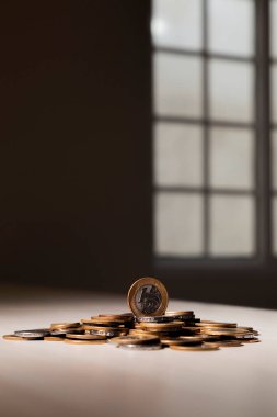 Gerçek para, Brezilya 'dan gelen para. Masanın üzerine para istiflenmiş, üstünde de siyah arka planlı kasvetli ve karanlık iklimli bir bozuk para var. Brezilya ekonomisi, yatırımlar, gelir. Brezilya para birimi 