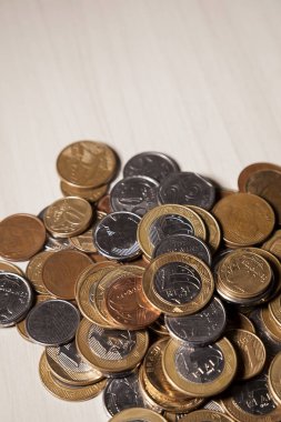 Gerçek para, Brezilya 'dan gelen para. Masanın üzerine para istiflenmiş, üstünde de siyah arka planlı kasvetli ve karanlık iklimli bir bozuk para var. Brezilya ekonomisi, yatırımlar, gelir. Brezilya para birimi 