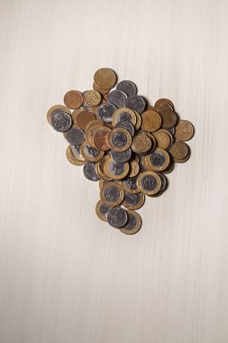 Gerçek para, Brezilya 'dan gelen para. Masanın üzerine para istiflenmiş, üstünde de siyah arka planlı kasvetli ve karanlık iklimli bir bozuk para var. Brezilya ekonomisi, yatırımlar, gelir. Brezilya para birimi 