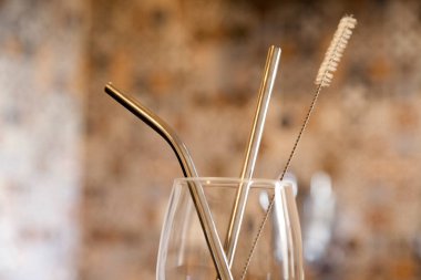 Mutfak tezgahında ekolojik kamış olan cam bardak. Döşeme arkaplanı ve kopyalama alanı var. Ekoloji konsepti. Konsepti yeniden kullan.