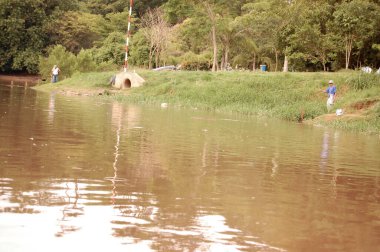 Arkasında değirmen olan Piracicaba Nehri