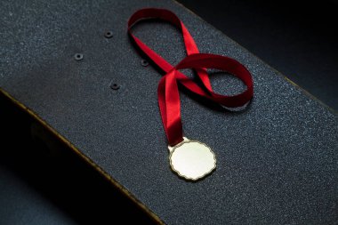 Siyah arka planda altın madalyalı kaykay