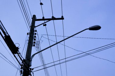 Mavi gökyüzü ve bir taraftan diğer tarafa giden elektrik kabloları. Şehir konsepti. Şehir konsepti.