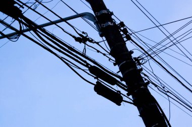 Mavi gökyüzü ve bir taraftan diğer tarafa giden elektrik kabloları. Şehir konsepti. Şehir konsepti.