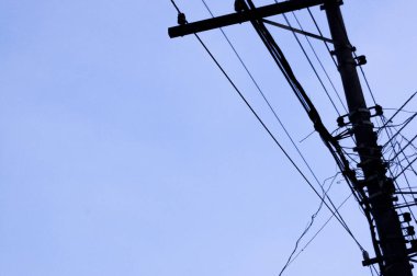 Mavi gökyüzü ve bir taraftan diğer tarafa giden elektrik kabloları. Şehir konsepti. Şehir konsepti.