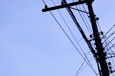 Mavi gökyüzü ve bir taraftan diğer tarafa giden elektrik kabloları. Şehir konsepti. Şehir konsepti.