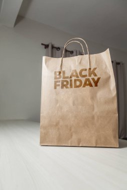 Karton poşet, arka planda özel yazı ve mutfak olan masa kahverengi kağıt ambalajına Kara Cuma yazılıydı. Kara Cuma konsepti. Ürün konsepti. Paketleme konsepti. Boşluğu kopyala