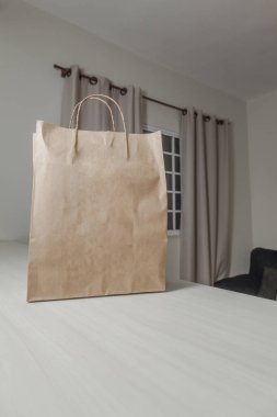 Ahşap masada reklam ve fotokopi alanı olan karton alışveriş torbası. Düz kahverengi karton çanta. Market çantası. Teslimat çantası. Yemek teslimatı konsepti. Nakliye kavramı