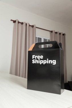 Tarafsız bir arkaplanı olan boş bir odada, yere bırakılan kutuda yazılı siparişin olduğu karton kutu. Teslimat. Ekonomi kavramı. İş konsepti. alışveriş kavramı. 