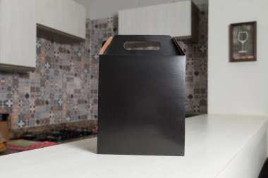 Ahşap masaya hediye paketi, reklam ve fotokopi alanı ile birlikte. Düz siyah karton kutu. Teslimat konsepti. Nakliye kavramı