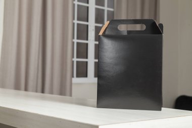 Ahşap masaya hediye paketi, reklam ve fotokopi alanı ile birlikte. Düz siyah karton kutu. Teslimat konsepti. Nakliye kavramı