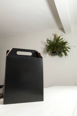 Ahşap masaya hediye paketi, reklam ve fotokopi alanı ile birlikte. Düz siyah karton kutu. Teslimat konsepti. Nakliye kavramı