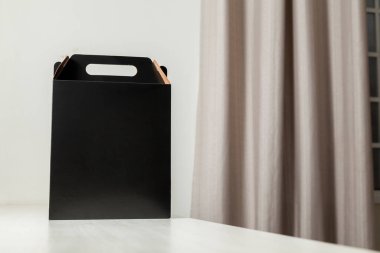 Ahşap masaya hediye paketi, reklam ve fotokopi alanı ile birlikte. Düz siyah karton kutu. Teslimat konsepti. Nakliye kavramı