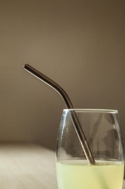 Ekolojik paslanmaz çelik pipetle masada limon suyu. Kopyalama alanı olan. Ekoloji konsepti. Konsepti yeniden kullan