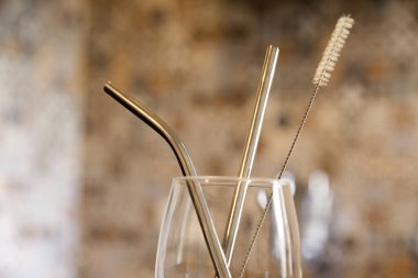 Mutfak tezgahında ekolojik kamış olan cam bardak. Döşeme arkaplanı ve kopyalama alanı var. Ekoloji konsepti. Konsepti yeniden kullan.