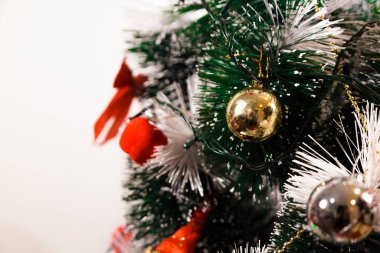 Christmas ornaments. With copy space and neutral background. Green Christmas tree with red and gold and silver ornaments. Year-end party concept. New year concept. Christmas lights.	