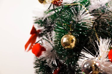 Christmas ornaments. With copy space and neutral background. Green Christmas tree with red and gold and silver ornaments. Year-end party concept. New year concept. Christmas lights.	