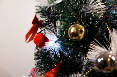 Christmas ornaments. With copy space and neutral background. Green Christmas tree with red and gold and silver ornaments. Year-end party concept. New year concept. Christmas lights.	
