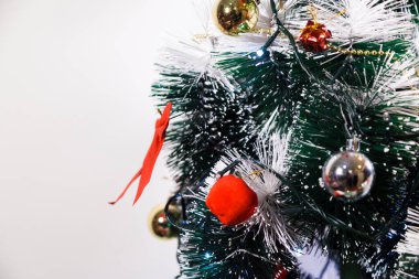 Christmas ornaments. With copy space and neutral background. Green Christmas tree with red and gold and silver ornaments. Year-end party concept. New year concept. Christmas lights.	
