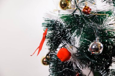 Christmas ornaments. With copy space and neutral background. Green Christmas tree with red and gold and silver ornaments. Year-end party concept. New year concept. Christmas lights.	