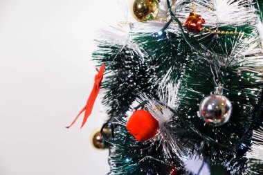 Christmas ornaments. With copy space and neutral background. Green Christmas tree with red and gold and silver ornaments. Year-end party concept. New year concept. Christmas lights.	