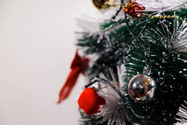 Christmas ornaments. With copy space and neutral background. Green Christmas tree with red and gold and silver ornaments. Year-end party concept. New year concept. Christmas lights.	