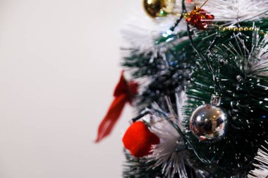 Christmas ornaments. With copy space and neutral background. Green Christmas tree with red and gold and silver ornaments. Year-end party concept. New year concept. Christmas lights.	