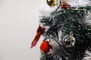 Christmas ornaments. With copy space and neutral background. Green Christmas tree with red and gold and silver ornaments. Year-end party concept. New year concept. Christmas lights.	