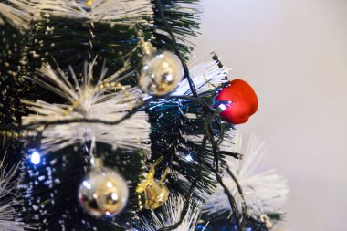 Christmas ornaments. With copy space and neutral background. Green Christmas tree with red and gold and silver ornaments. Year-end party concept. New year concept. Christmas lights.	