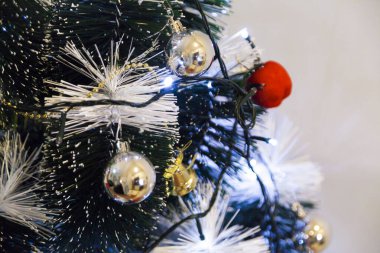 Christmas ornaments. With copy space and neutral background. Green Christmas tree with red and gold and silver ornaments. Year-end party concept. New year concept. Christmas lights.	