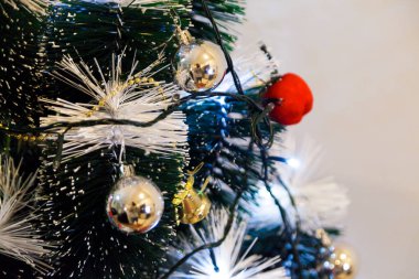 Christmas ornaments. With copy space and neutral background. Green Christmas tree with red and gold and silver ornaments. Year-end party concept. New year concept. Christmas lights.	