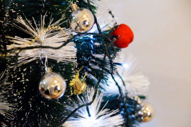 Christmas ornaments. With copy space and neutral background. Green Christmas tree with red and gold and silver ornaments. Year-end party concept. New year concept. Christmas lights.	