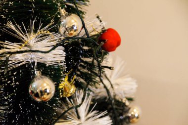 Christmas ornaments. With copy space and neutral background. Green Christmas tree with red and gold and silver ornaments. Year-end party concept. New year concept. Christmas lights.	
